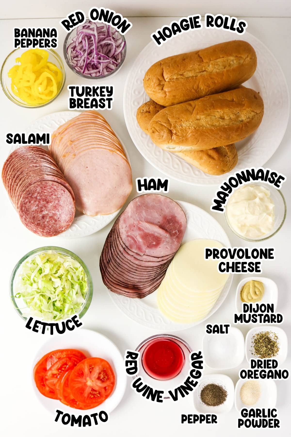 Ingredients for a hoagie sandwich arranged in separate bowls and plates.