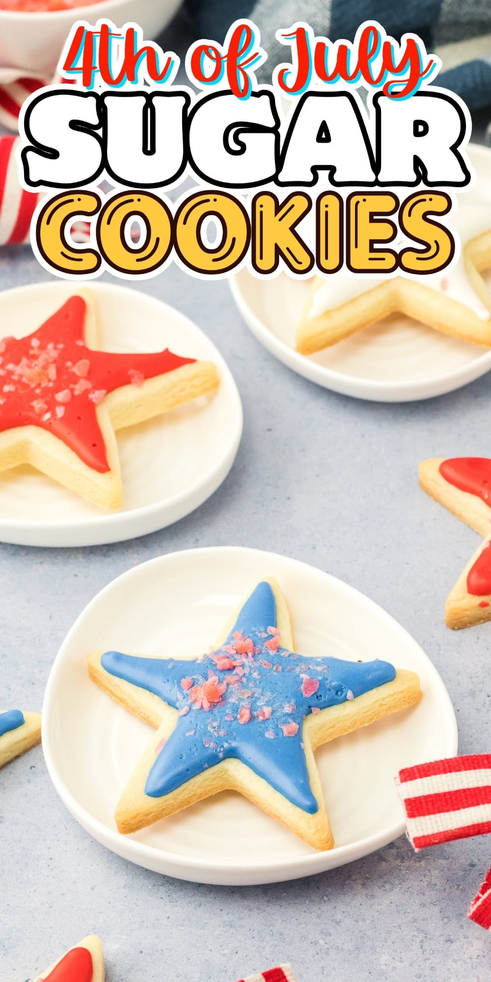 Star-shaped sugar cookies with red and blue icing on small white plates.