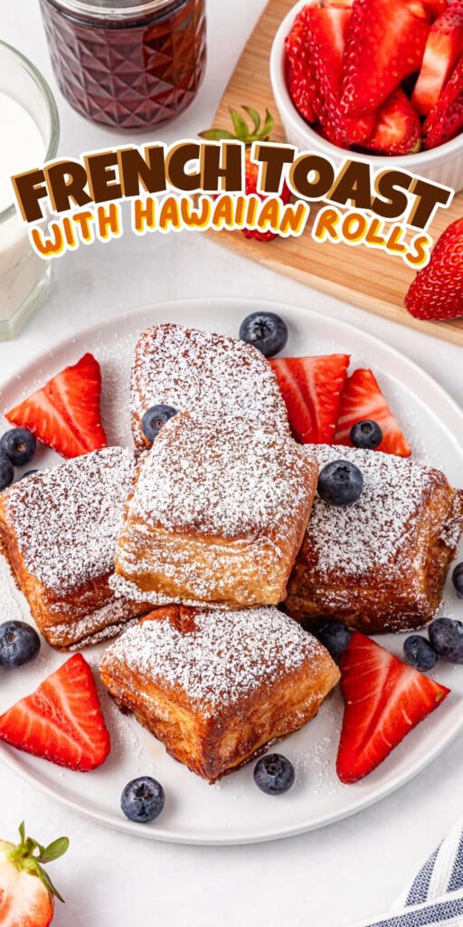 French toast bites with strawberries, blueberries, and powdered sugar on plate.