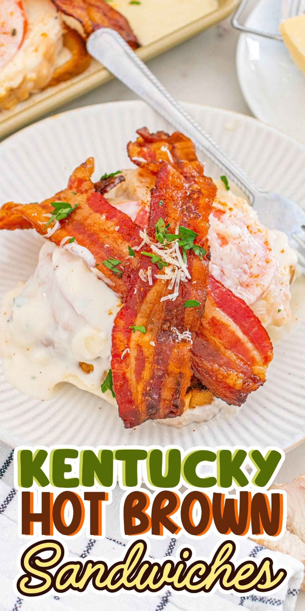 Two bacon-topped sandwiches covered in creamy sauce on a white plate.