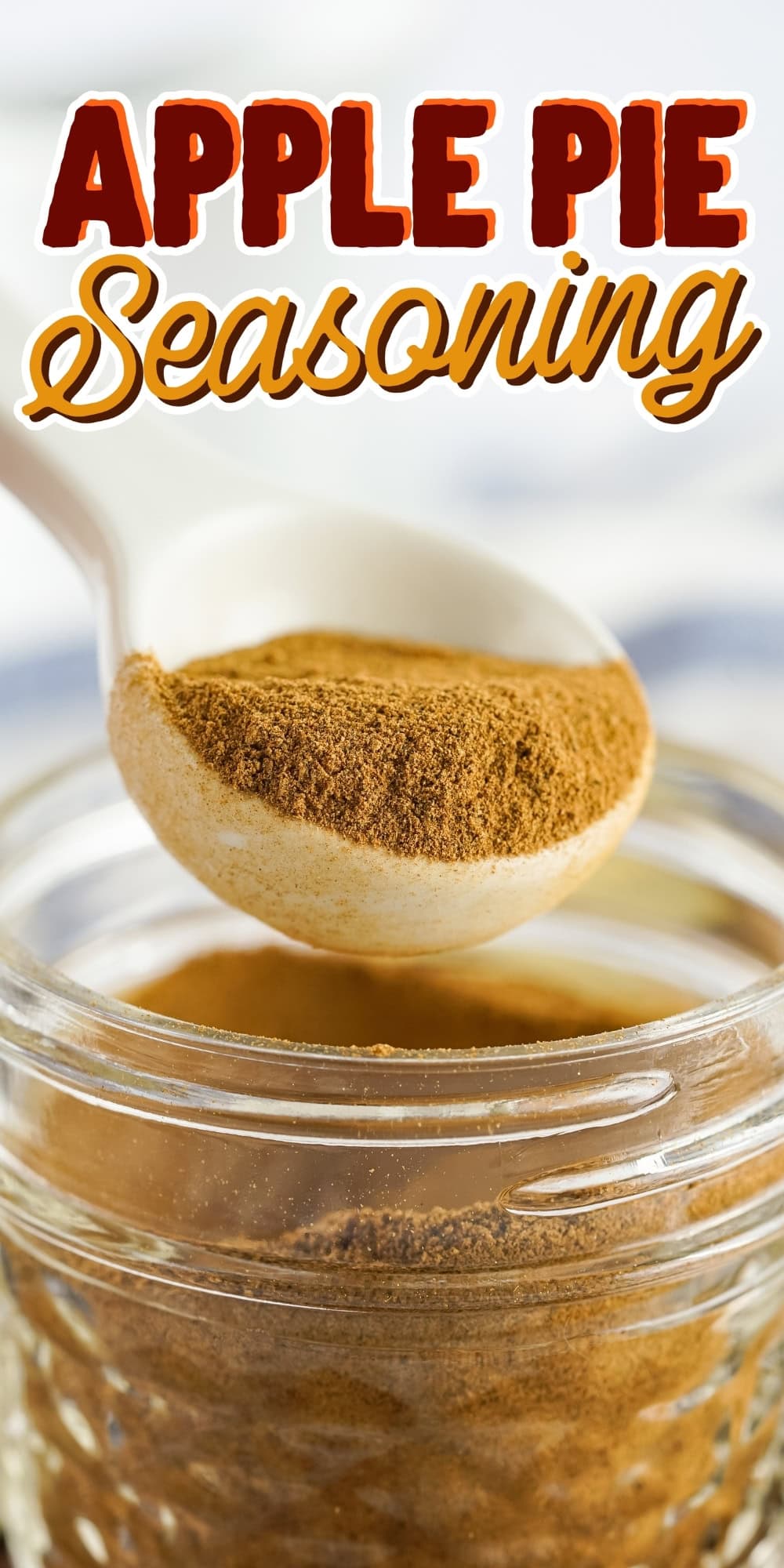 Apple Pie Seasoning in a jar with a spoonful of the spice mix above it.