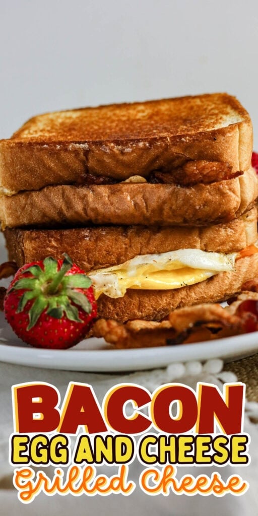 Stacked bacon, egg, and cheese grilled cheese sandwiches with a strawberry.