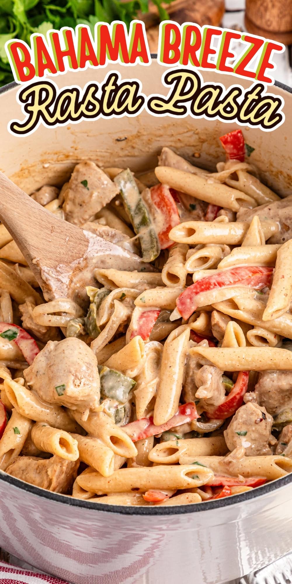 Pasta, chicken, and veggies in creamy sauce being stirred in a large white pot.