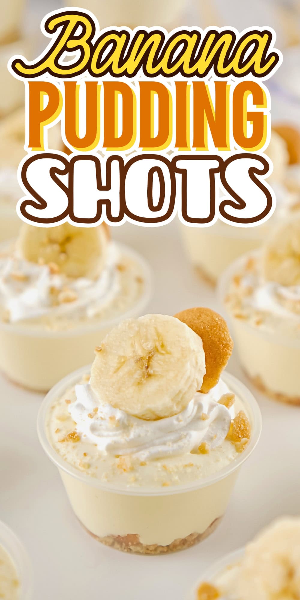 Mini banana pudding shots topped with whipped cream, banana slice, and a cookie.