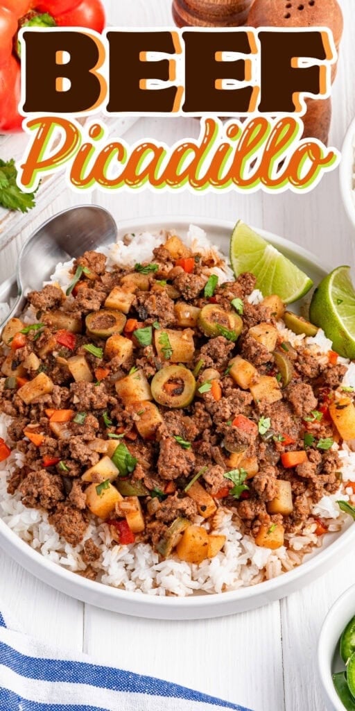 A bowl of beef picadillo with rice, potatoes, olives, and lime wedges.