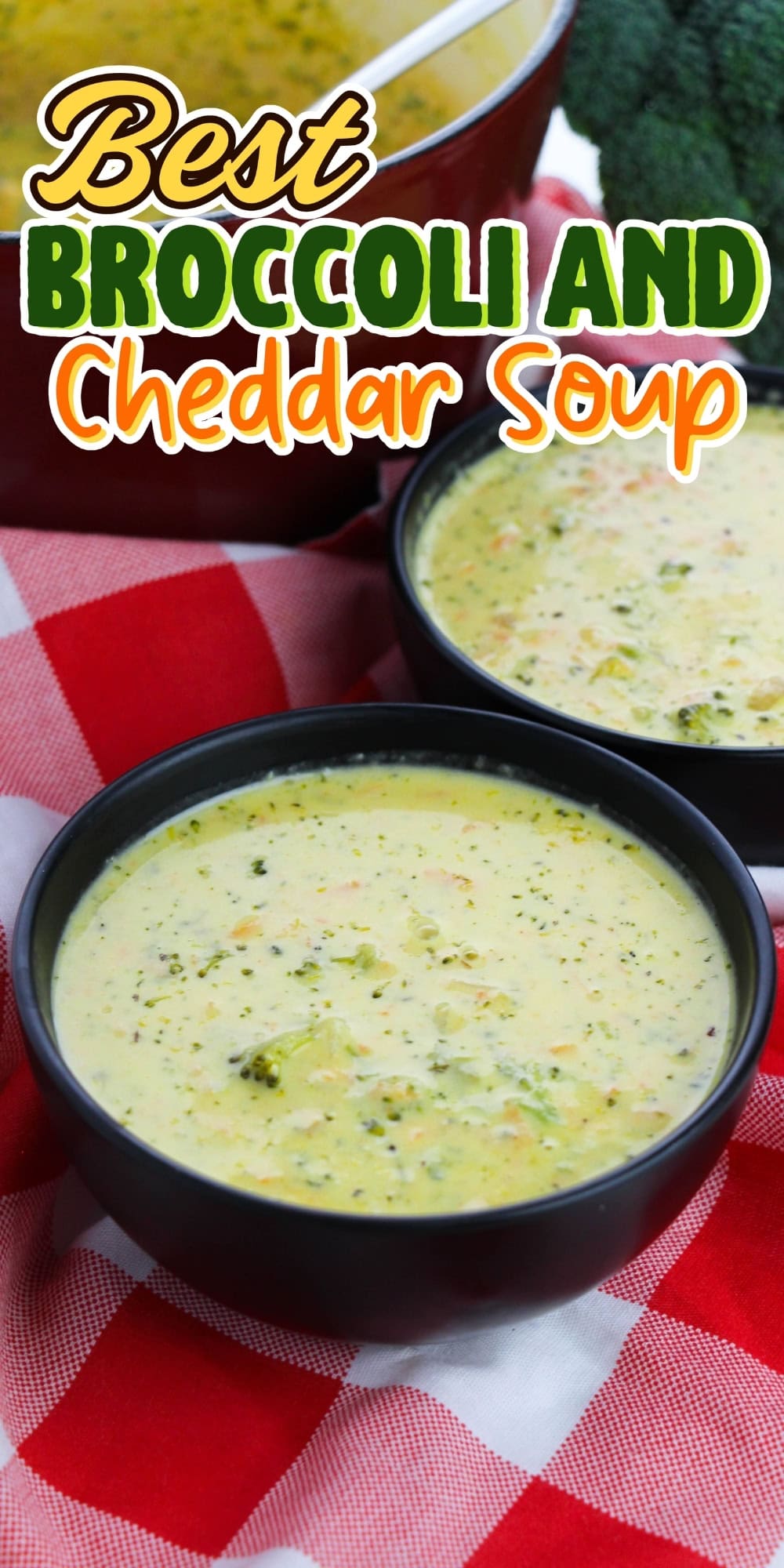 Two bowls of broccoli cheddar soup on a red checkered tablecloth.