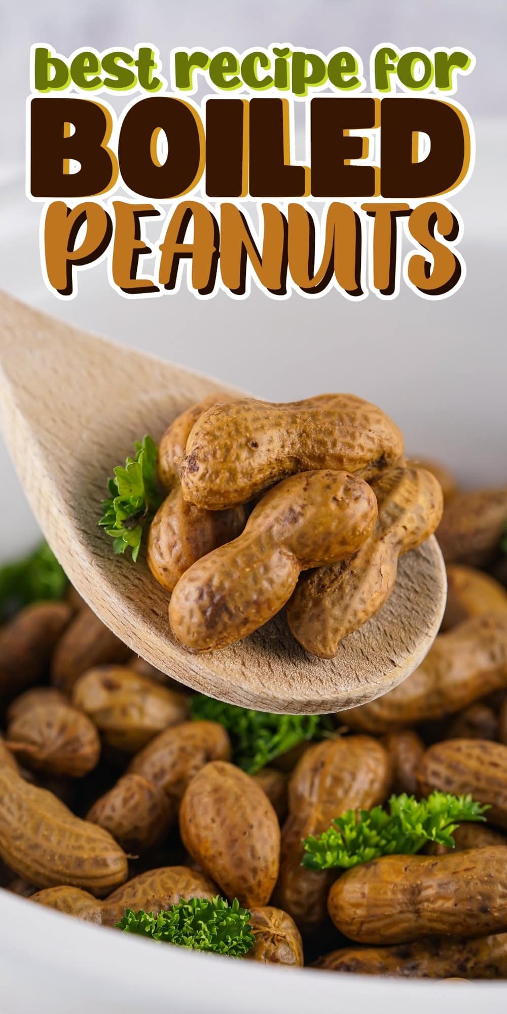 A wooden spoon holds boiled peanuts over a bowl, garnished with parsley.