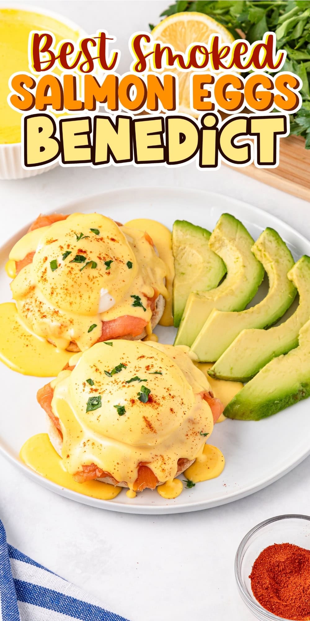 Two smoked salmon eggs benedict with avocado slices on a white plate.