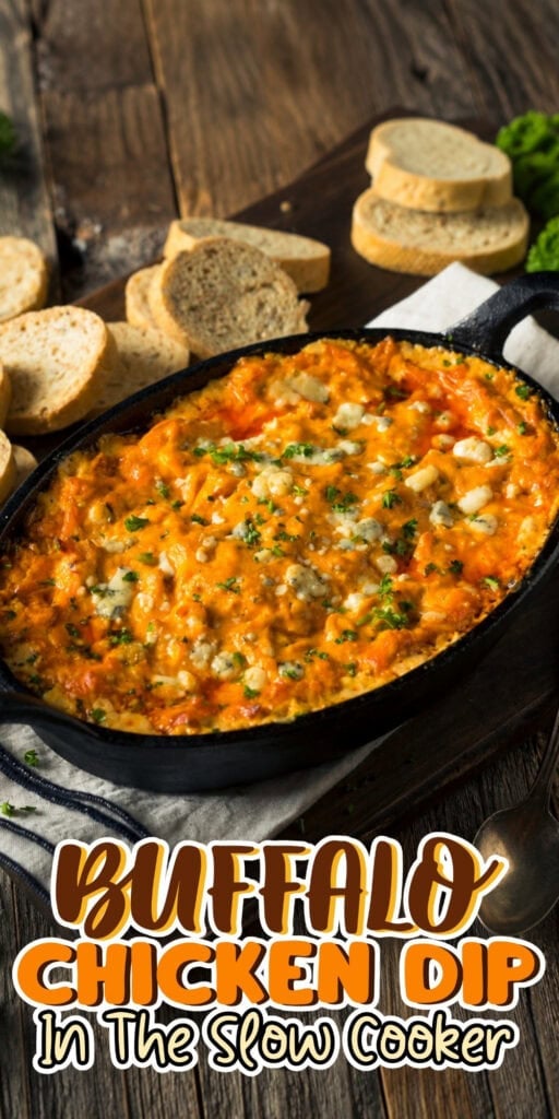 Buffalo chicken dip in a skillet with bread slices on a wooden table.