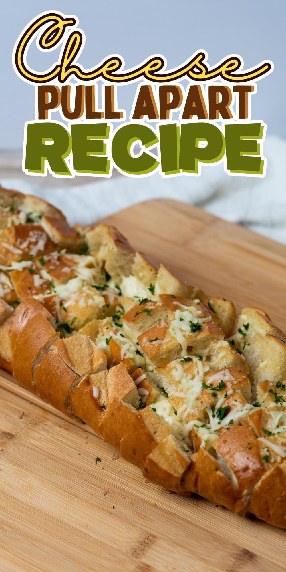 Sliced cheesy pull-apart bread on a wooden cutting board.