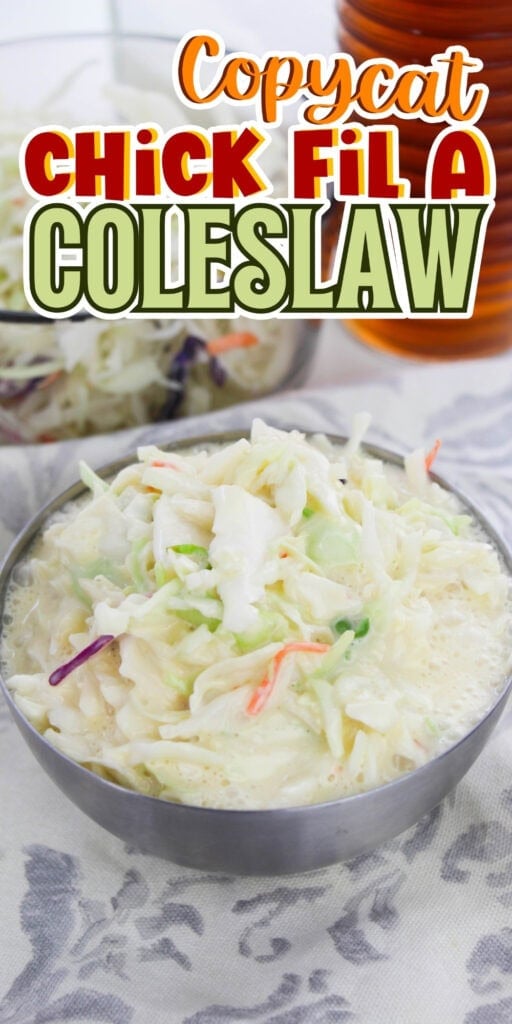 Bowl of creamy coleslaw with shredded cabbage and carrots on a table.