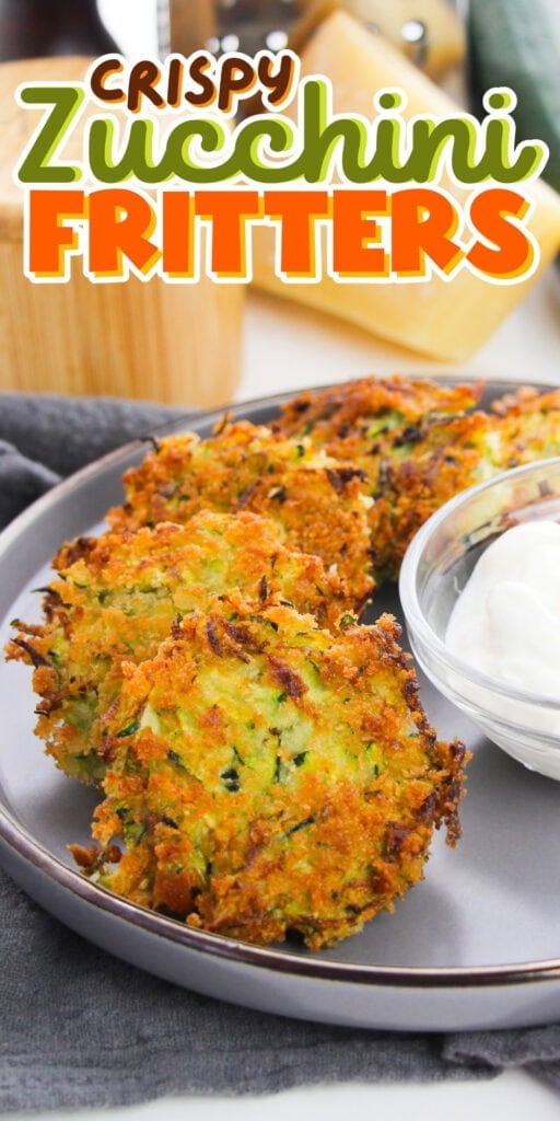 Three crispy zucchini fritters on a plate with a bowl of white dipping sauce.