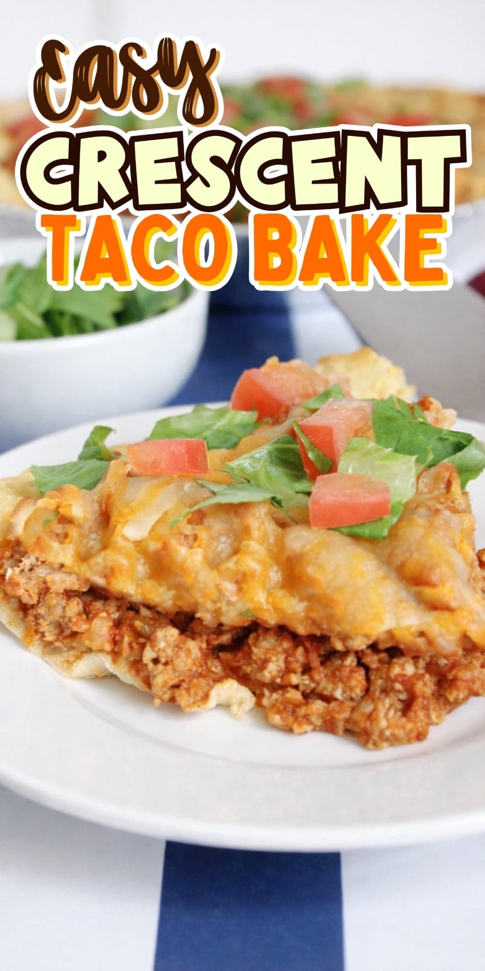 Two slices of cheesy taco bake with lettuce and tomato on a white plate.