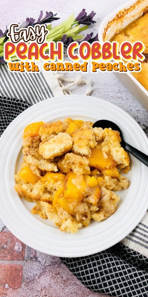 A plate of peach cobbler with a spoon, next to a baking dish and flowers.