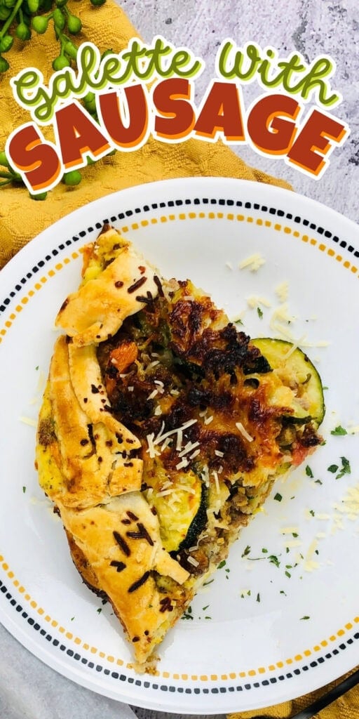 A slice of sausage galette on a white plate, topped with shredded cheese.