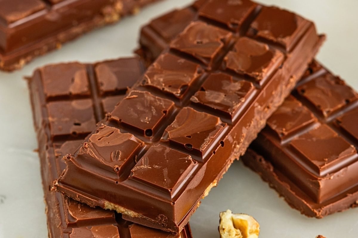 Stacked dark chocolate bars on a white surface.