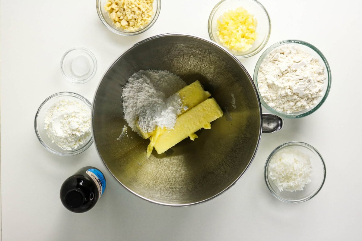 Butter, sugar, and flour in a mixing bowl, surrounded by baking ingredients.