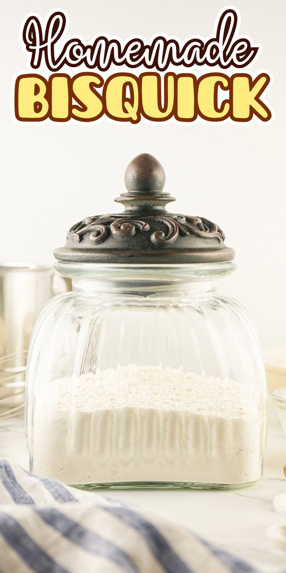 A glass jar of homemade Bisquick sits on a kitchen counter.