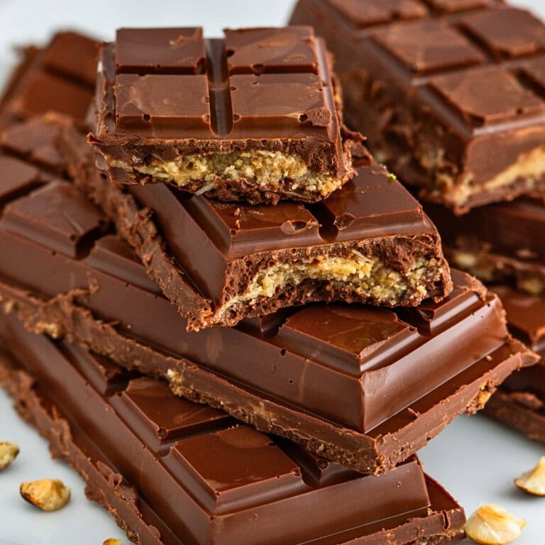 Stacked chocolate bars with crunchy nut filling, close-up view.