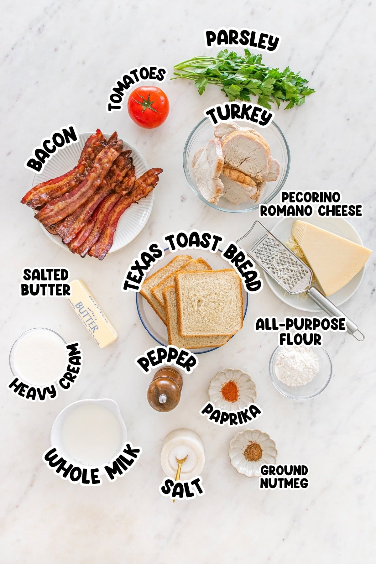 Ingredients for a turkey sandwich arranged on a white tabletop.