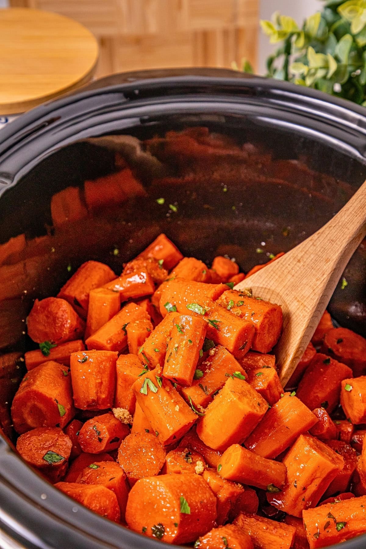 Tender carrots cooked in a slow cooker, topped with herbs and spices.
