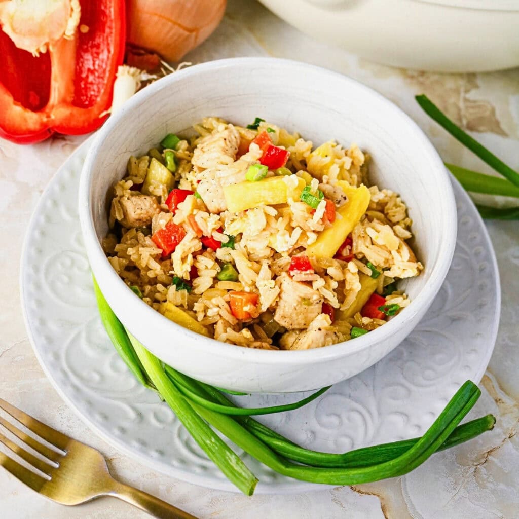 Bowl of fried rice with chicken, pineapple, peppers, and green onions.