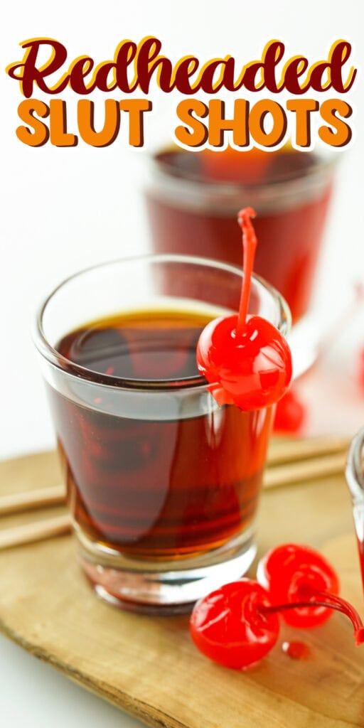 Shot glass with red liquid and cherry.