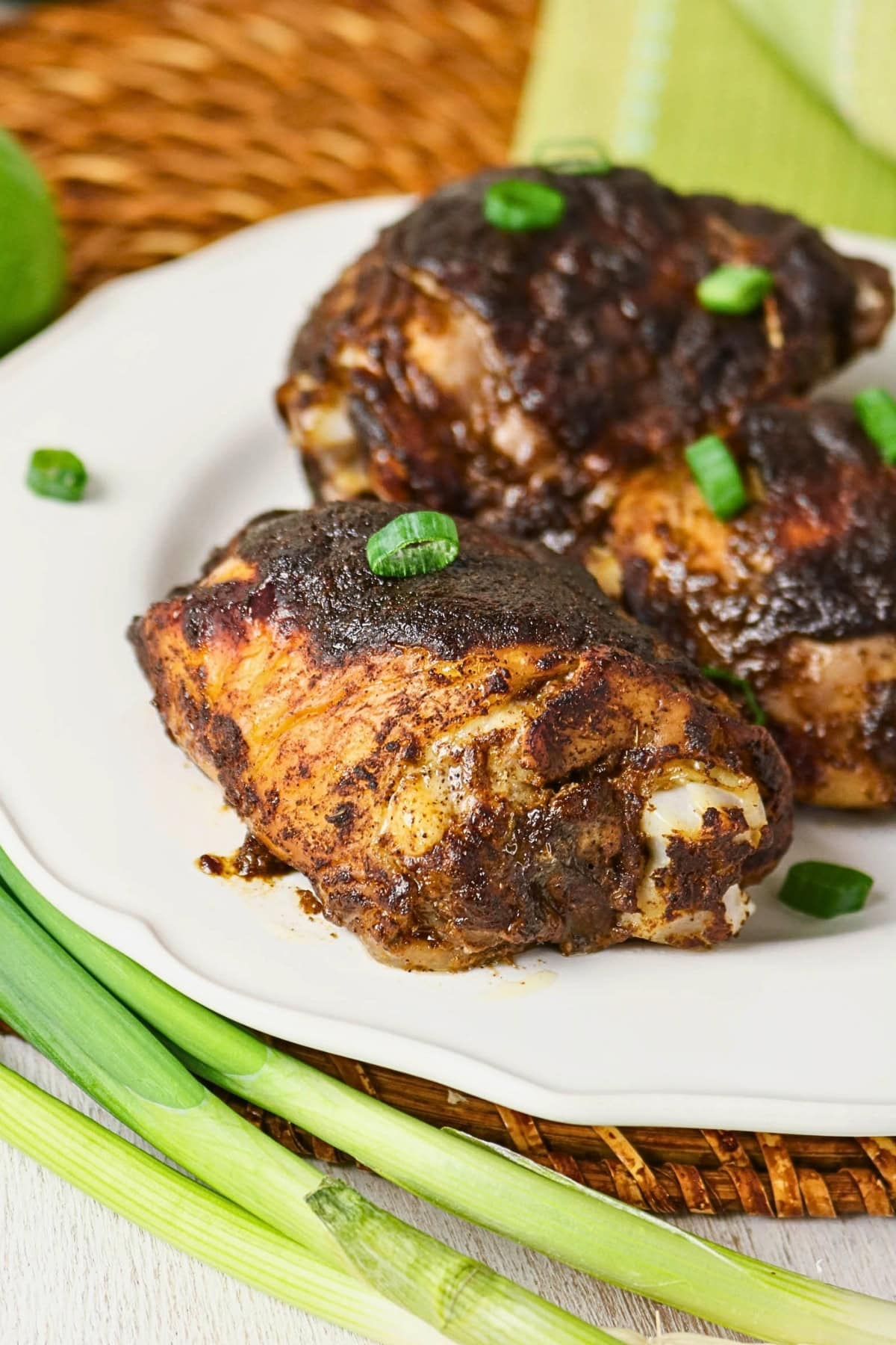 Three pieces of seasoned grilled chicken garnished with chopped green onions.