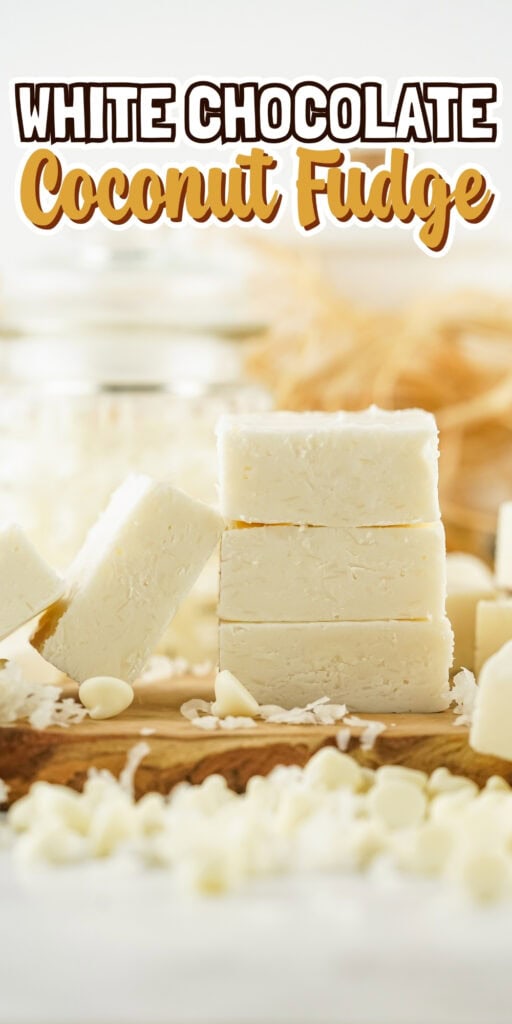 White chocolate coconut fudge squares stacked on a wooden board.