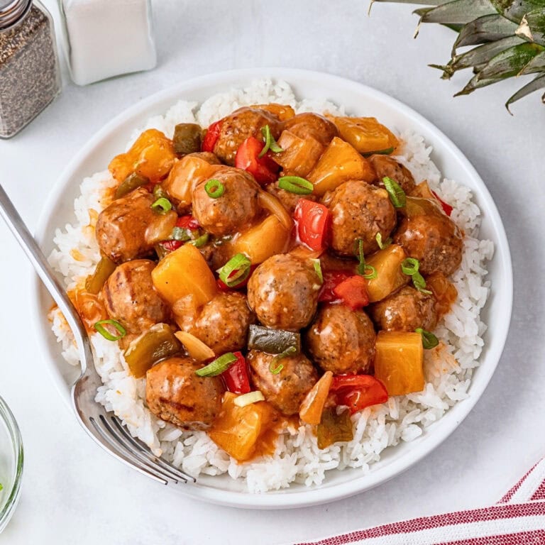 Meatballs with rice, bell peppers, and pineapple chunks in a sweet sauce.