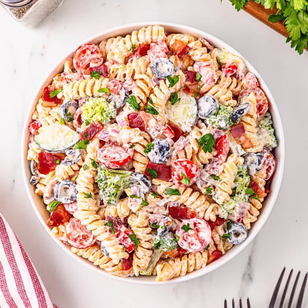 Pasta salad with rotini, tomatoes, broccoli, olives, and creamy dressing.