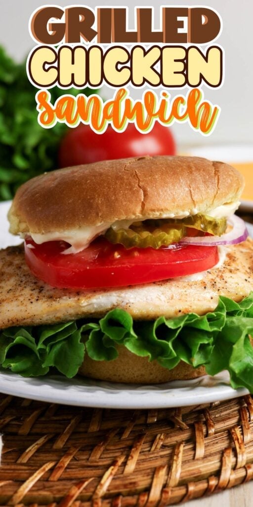 Grilled chicken sandwich with lettuce, tomato, pickles, and onions on a bun.