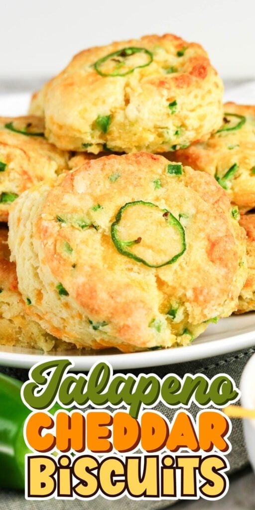 Golden biscuits with jalapeño slices, cheddar, and green herbs on a plate.