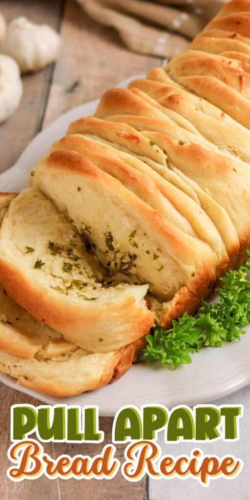 Sliced pull-apart bread with herbs on a white plate, garnish of parsley.