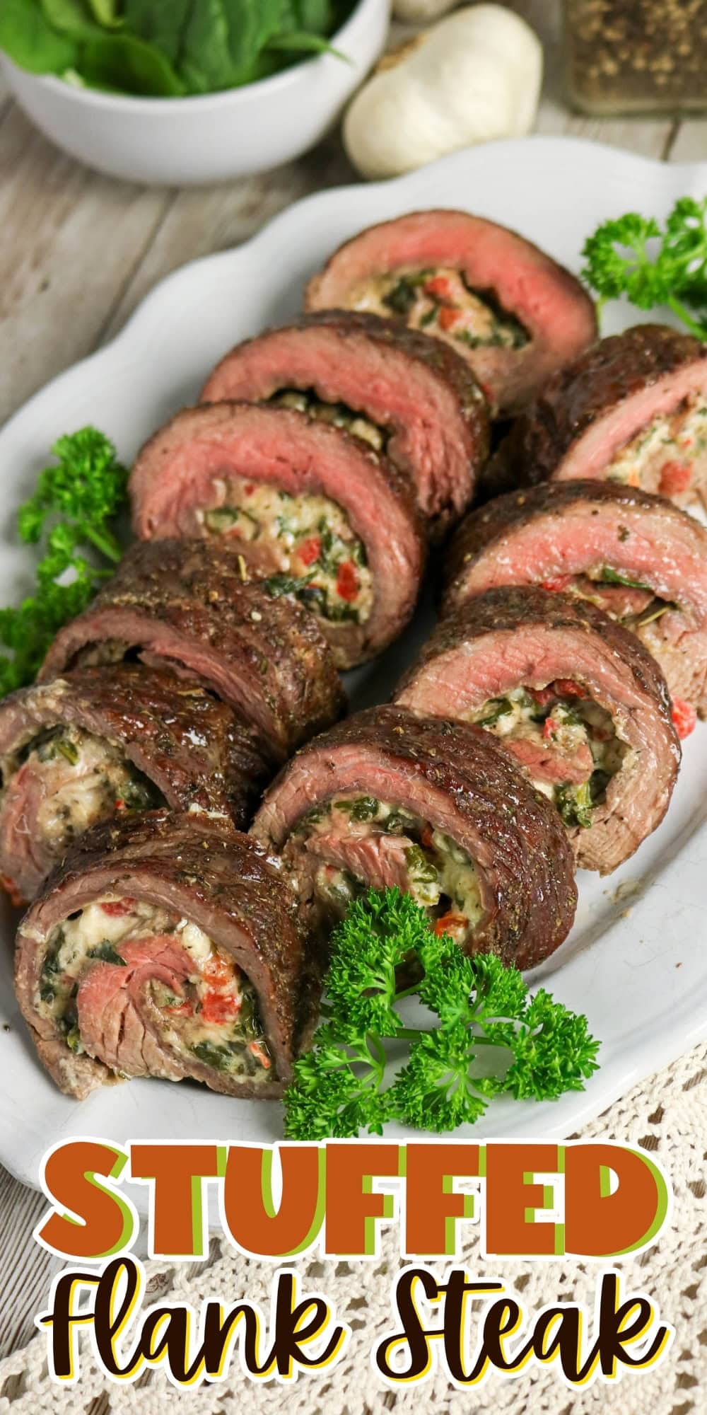 Sliced stuffed flank steak on a white plate, garnished with parsley.