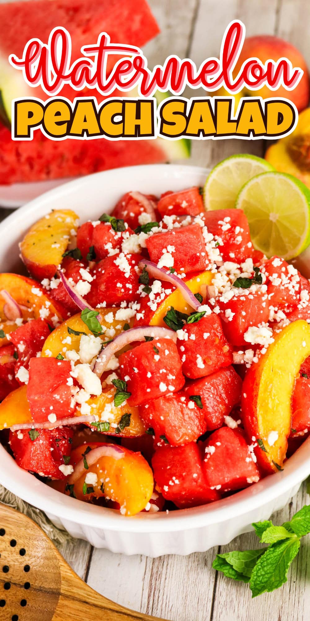 Bowl of watermelon peach salad topped with feta, mint, and lime slices.