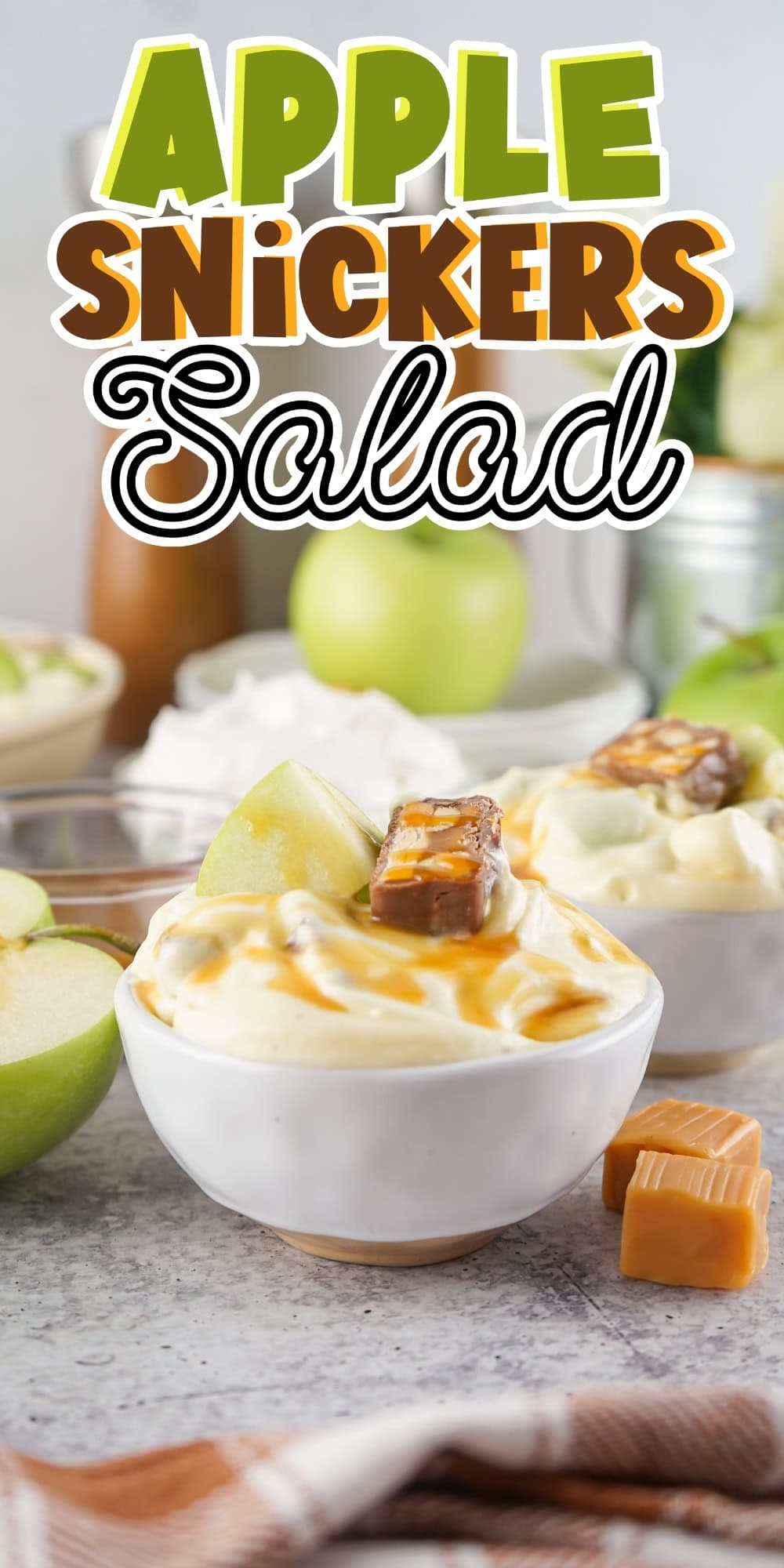 Bowl of creamy apple Snickers salad topped with caramel and apple slices.