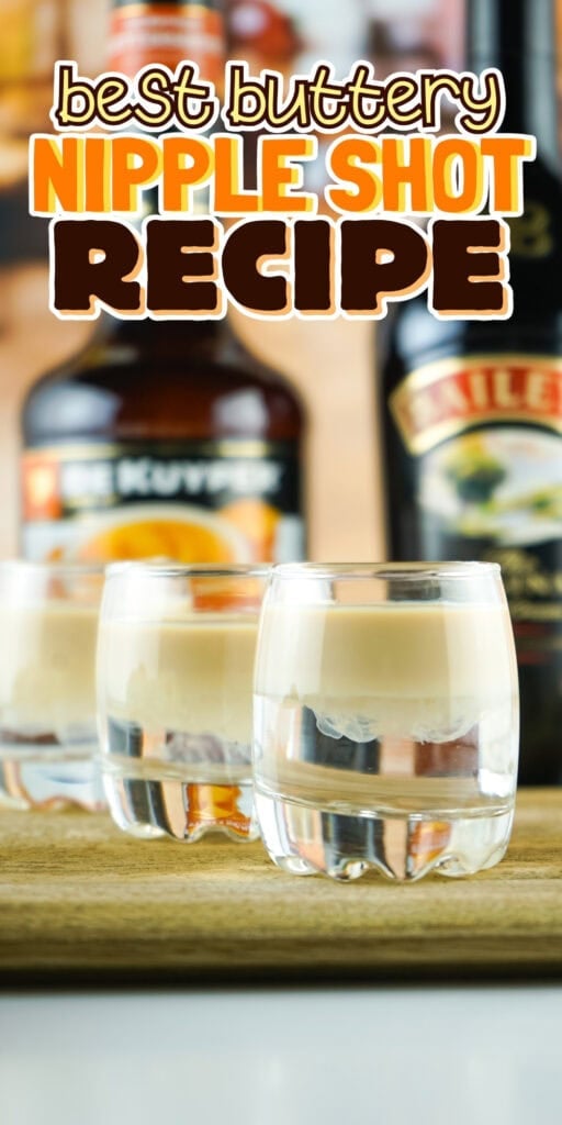 Three layered shots on a wooden board with liqueur bottles in the background.