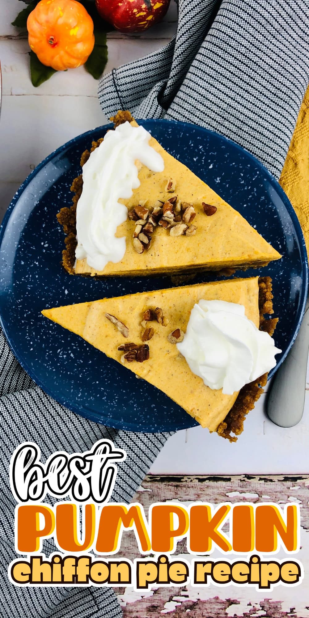 Two pumpkin pie slices with whipped cream and pecans on a blue plate.