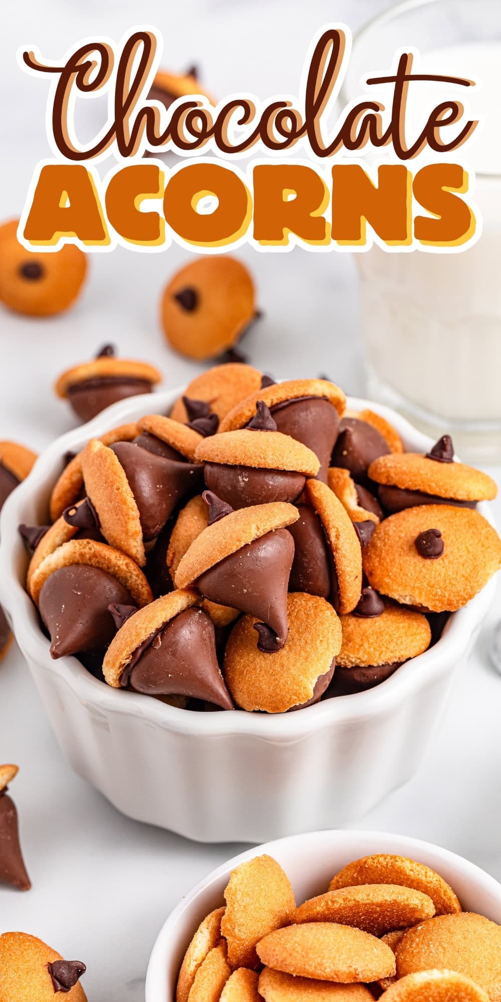 A bowl of chocolate acorn cookies with a glass of milk in the background.