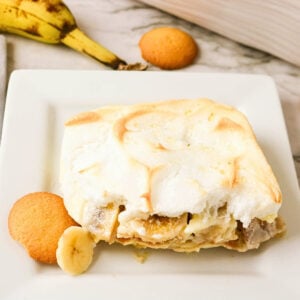 Banana pudding with vanilla wafers and banana slices on a white plate.