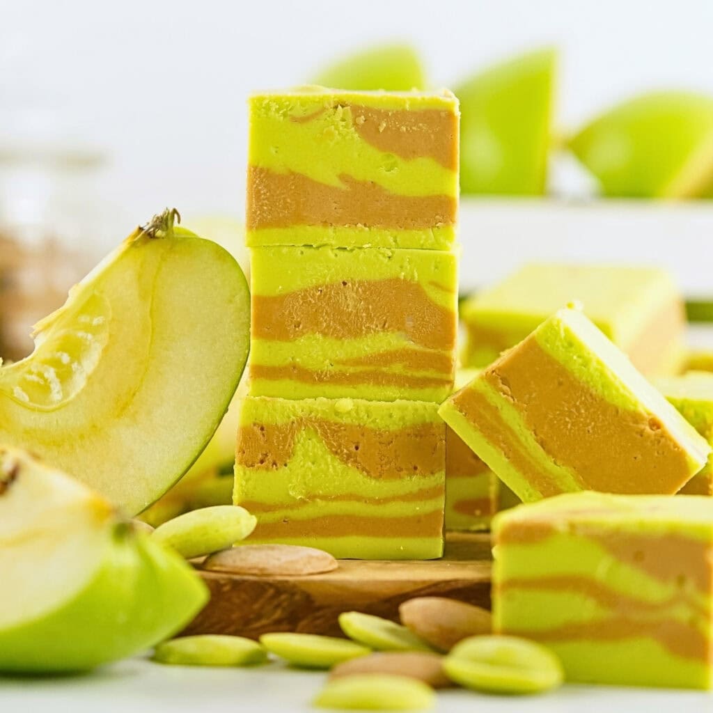 Green and caramel fudge squares with sliced green apples around them.