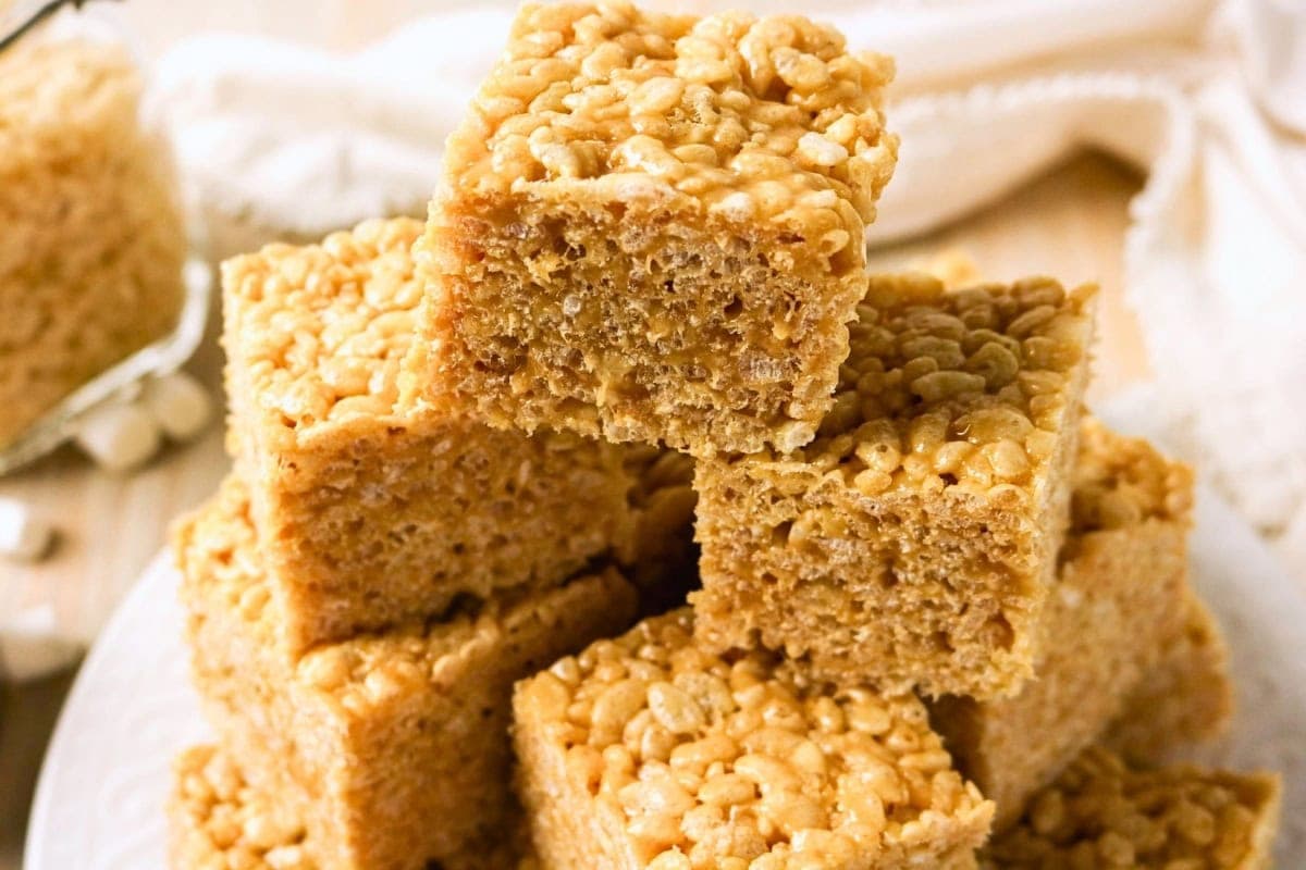 A stack of Rice Krispies treats on a white plate.