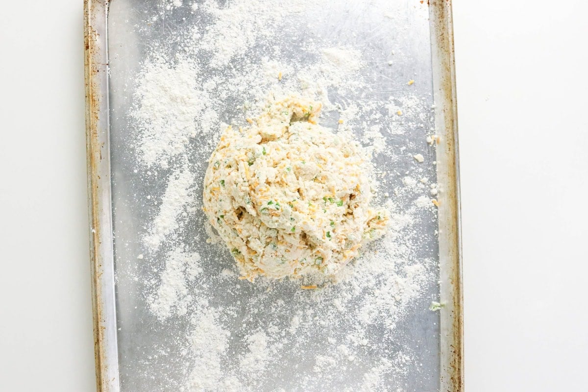 A ball of dough on a floured baking sheet.