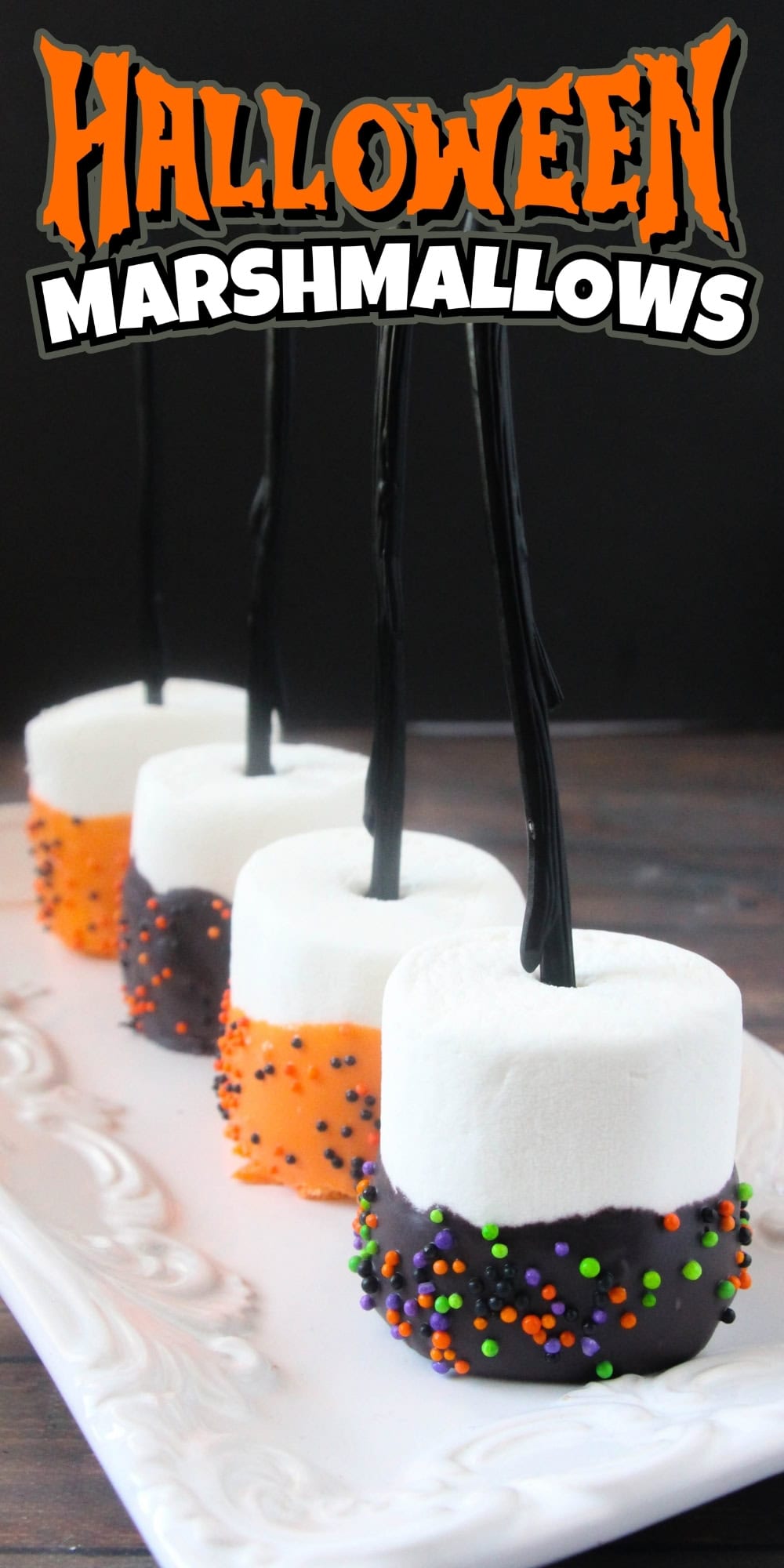 Chocolate-dipped Halloween marshmallows with sprinkles on black sticks.