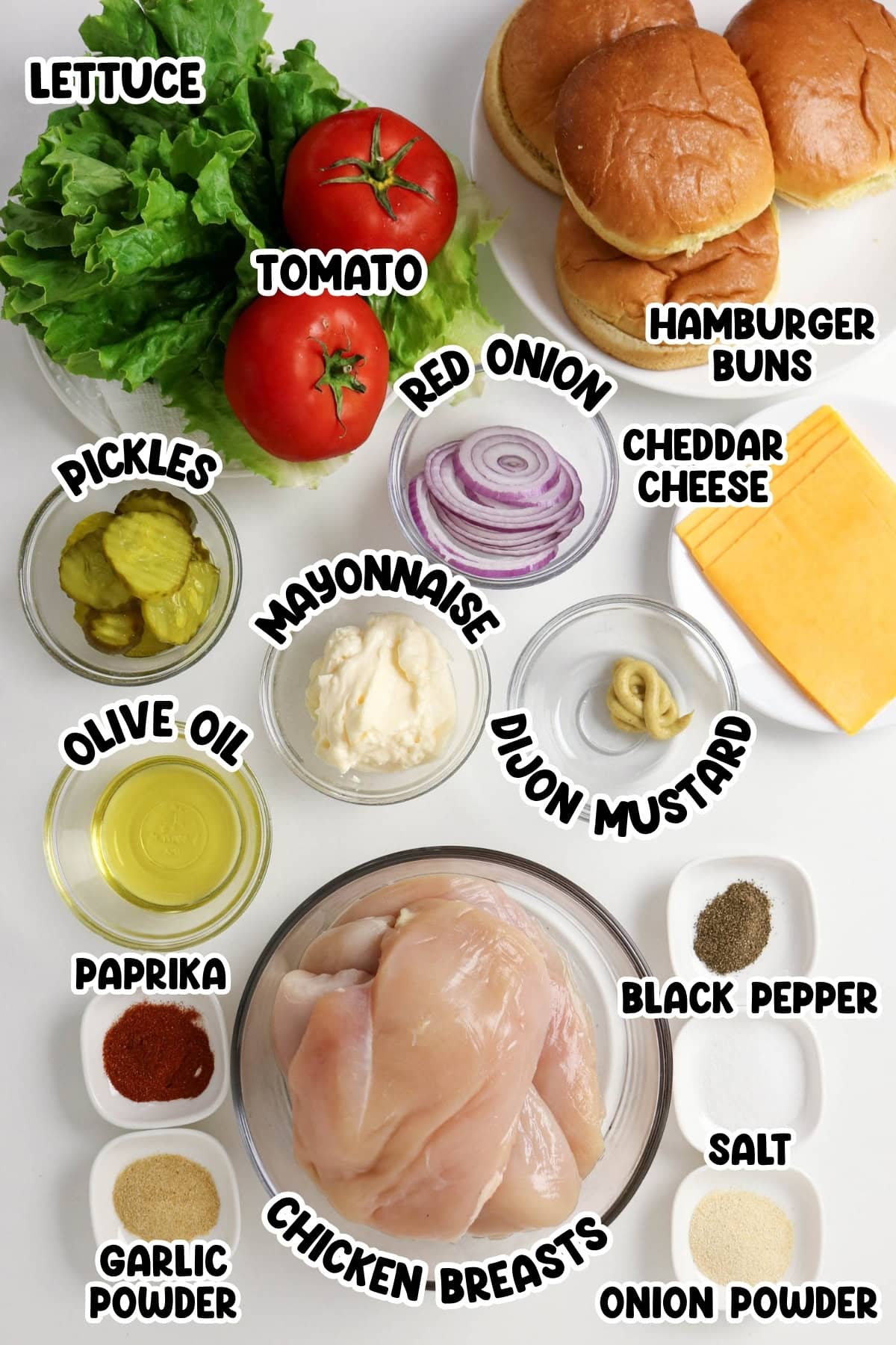 Ingredients for chicken sandwiches arranged on a white.