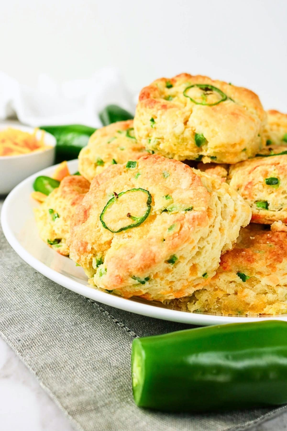 A plate of jalapeño cheddar biscuits garnished with jalapeño slices.