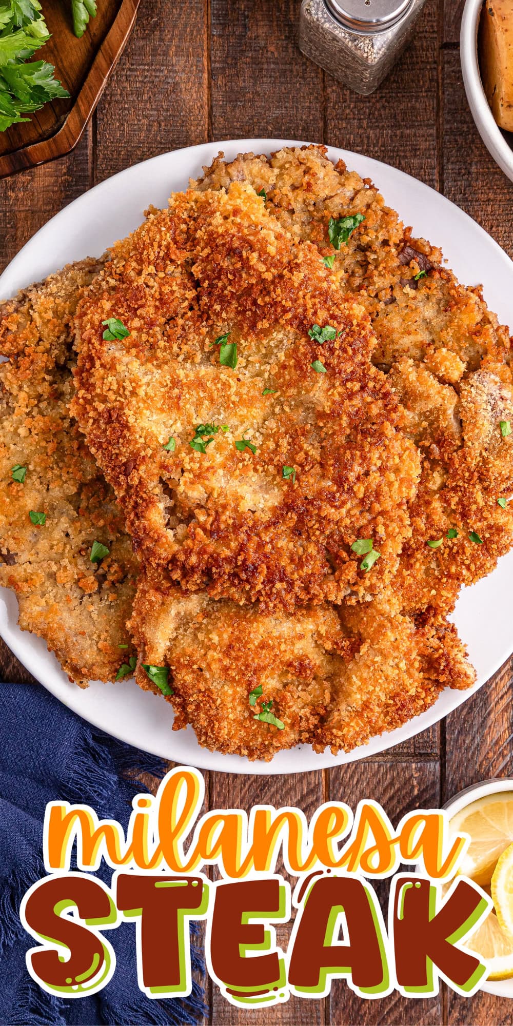 Plate of crispy breaded milanesa steak garnished with parsley on a wooden table.