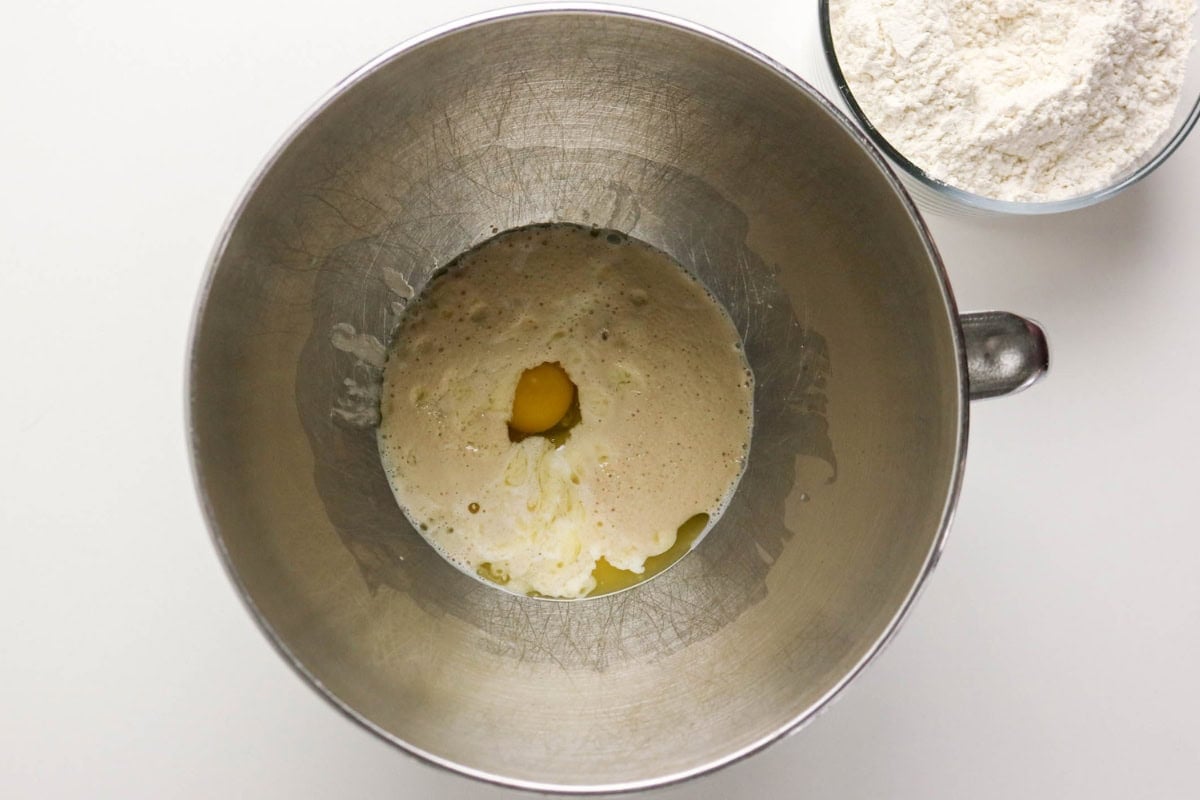 Mixing bowl with wet ingredients and a separate bowl of flour nearby.