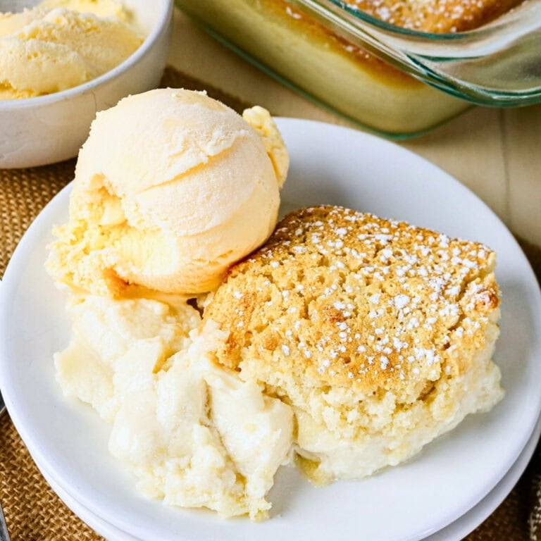Vanilla ice cream with a slice of cobbler on a white plate.